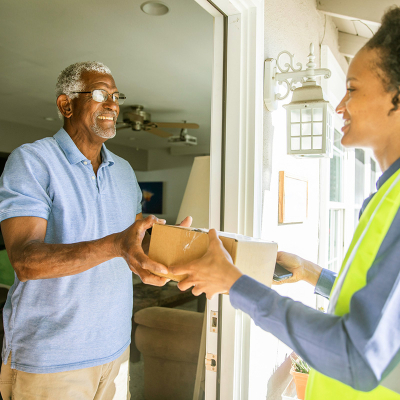 delivery woman handing man a package