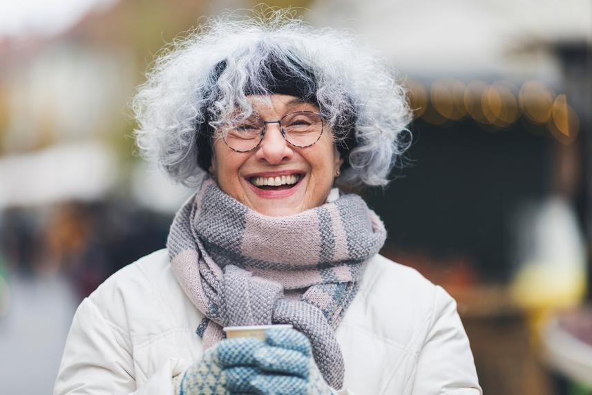 A senior wears a winter coat, headband, scarf and gloves