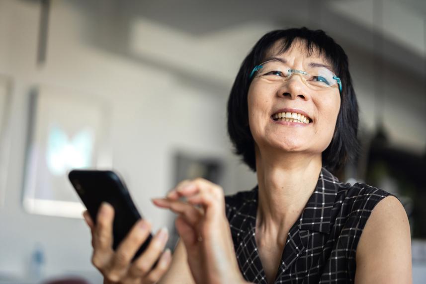 Senior woman smiling and using a smart phone