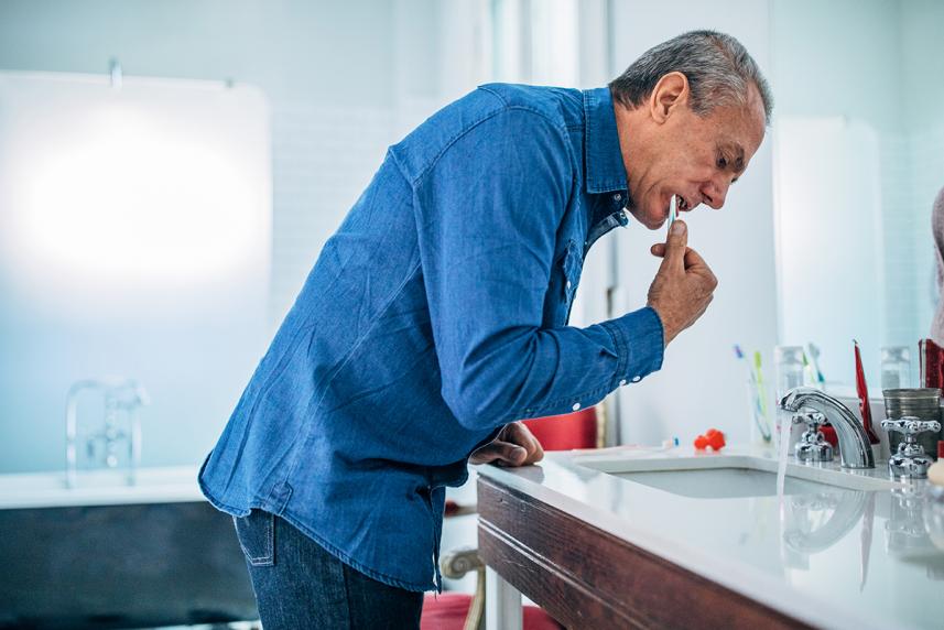 A senior brushes teeth