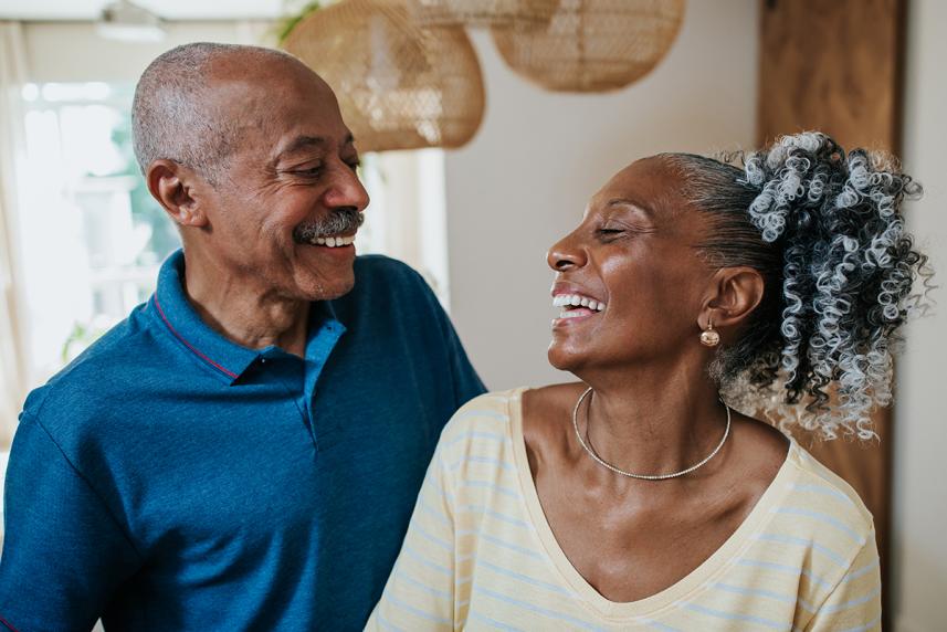 An elderly couple laughs and looks at each other