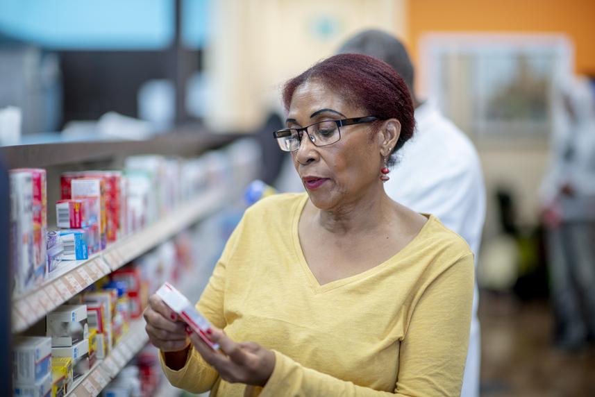 A senior looks at medication in a drugstore 