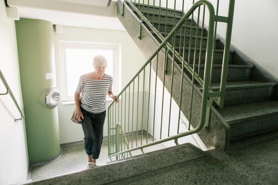 A senior woman walks up stairs