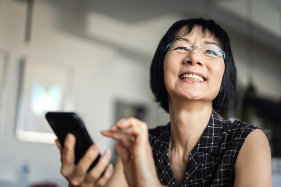 Senior woman smiling and using a smart phone