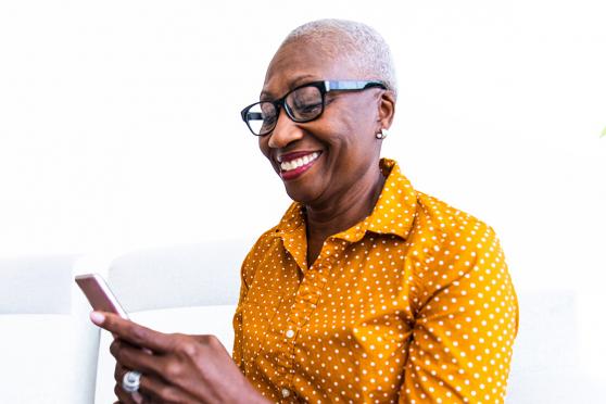 A woman smiling at her phone