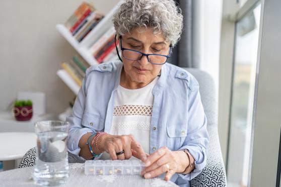 A senior uses a pill organizer