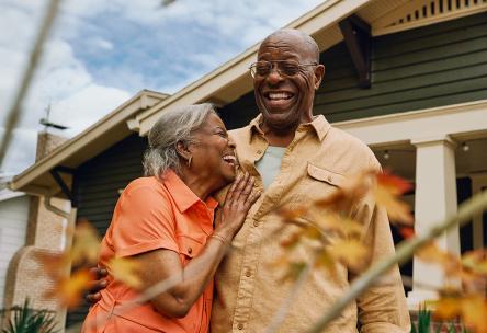 Couple hugging in front of a house