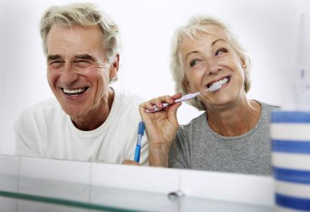 A couple brushing their teeth.