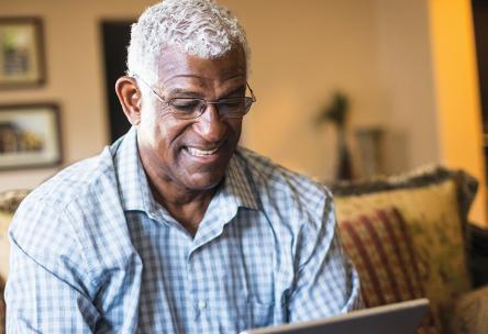 An older man looks at an iPad