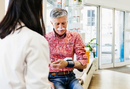 Senior man having his blood pressure checked at clinic or pharmacy