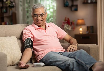 A senior uses a blood pressure monitor at home