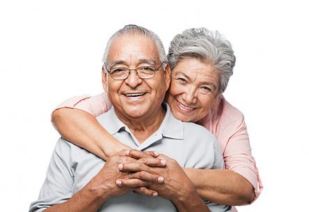 A woman hugging a man from behind.