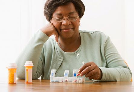 A senior uses a pill organizer