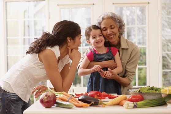 A grandmother, daughter and granddaughter prepare a meal