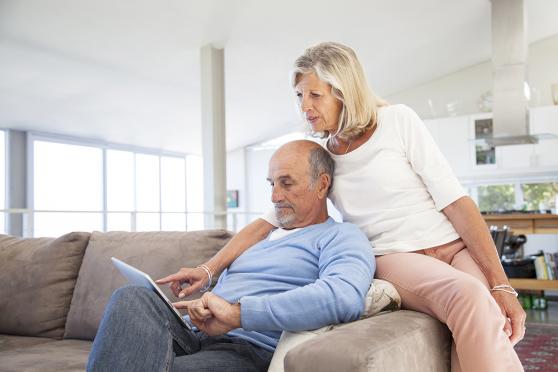 An older couple looks at a tablet screen