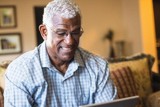 An older man looks at an iPad