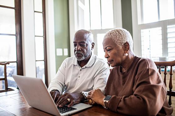 A couple looking at a laptop.