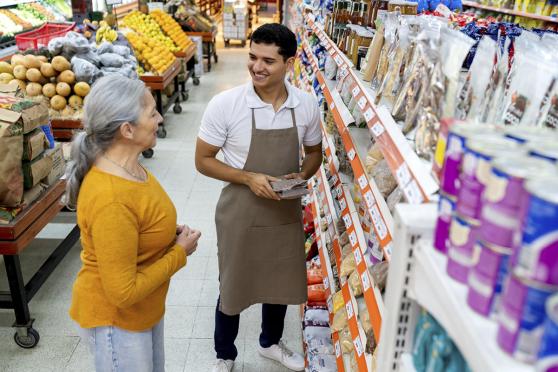 Man helping older woman at grocery store