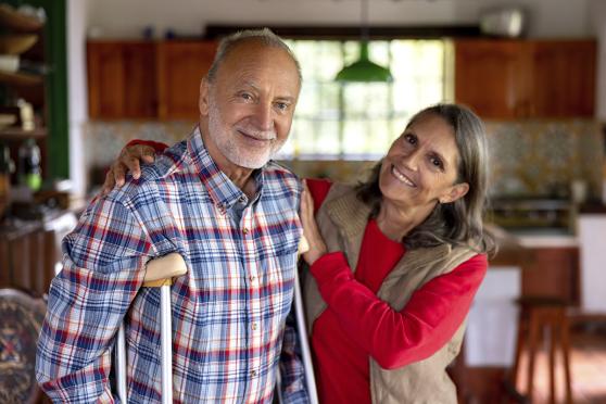 Man on crutches standing next to woman